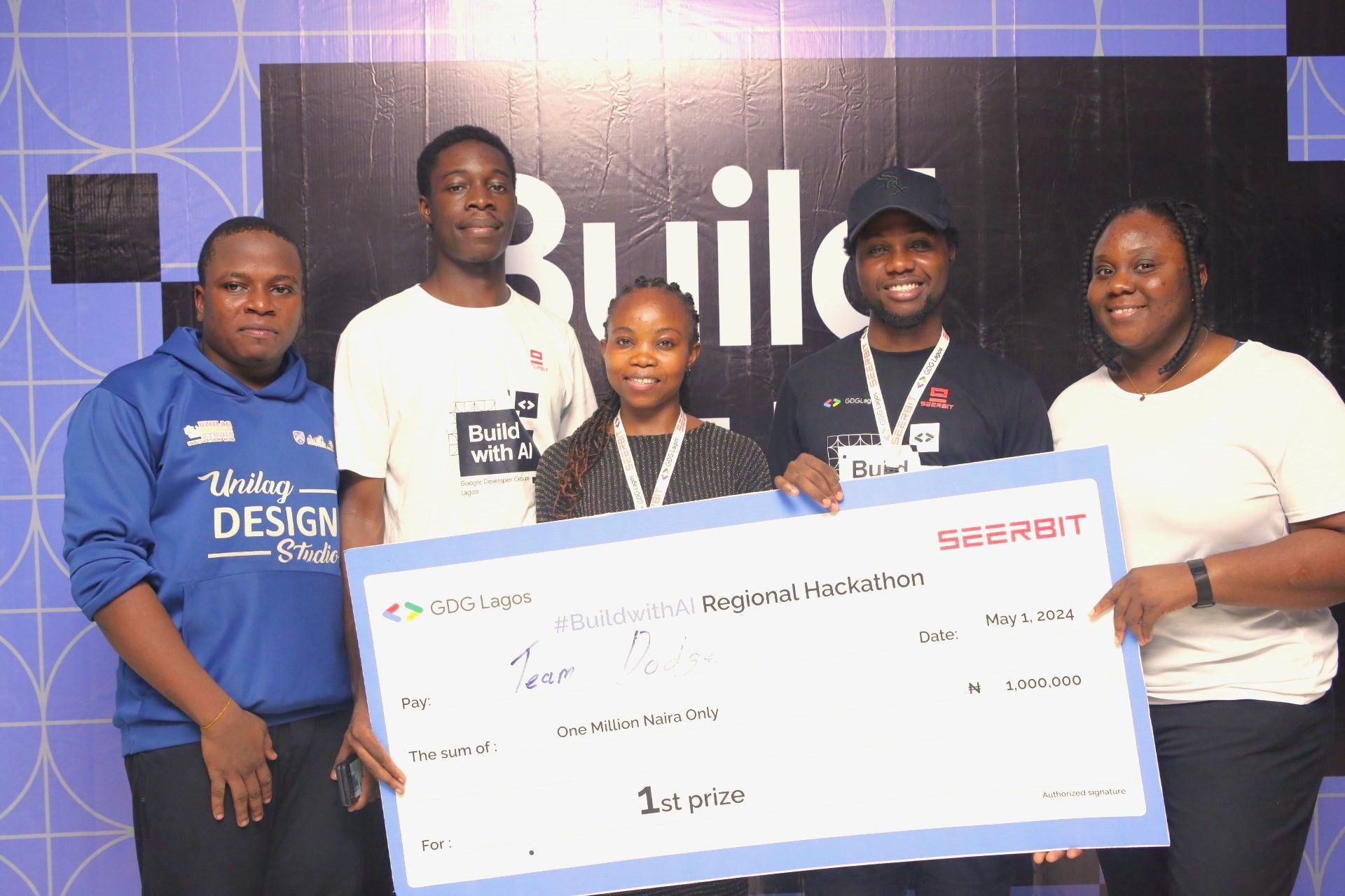 5 people standing holding a large winner receipt